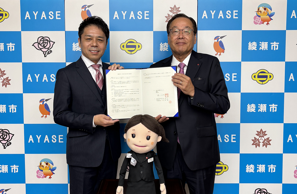 「綾瀬市民への終活支援に関する協定」締結書を持つ橘川佳彦市長と比企武代表取締役社長